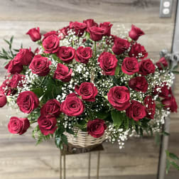 Basket arrangement of red roses with baby's breath