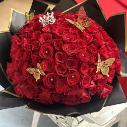 Large bouquet of red roses with butterfly decorations in black and gold wrap