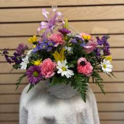 Mixed bouquet in a white basket with a lavender ribbon
