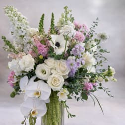 White and pastel pink floral arrangement in a clear glass vase