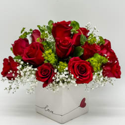 Red roses in a white square box with baby’s breath