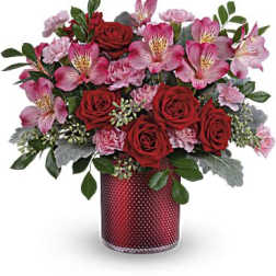 Red roses and pink flowers arranged in a red vase