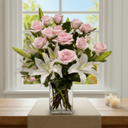 Pink roses and white lilies in a clear glass vase