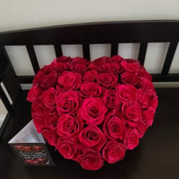 Heart-shaped bouquet of red roses on a black chair