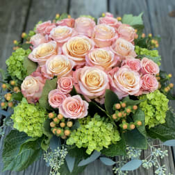Bouquet of pale pink and peach roses with green hydrangeas