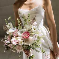 Bride holding a pastel bouquet with white and pink flowers