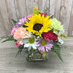 Mixed bouquet with a sunflower in a glass vase