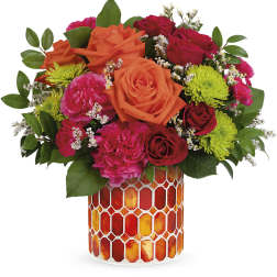 Bouquet of orange and red roses with pink carnations in a patterned vase