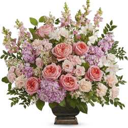 Pink roses and mixed blooms arranged in a dark vase