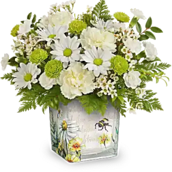 White daisies and green pom flowers in a decorated square vase