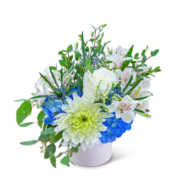 White and blue floral arrangement in a white container