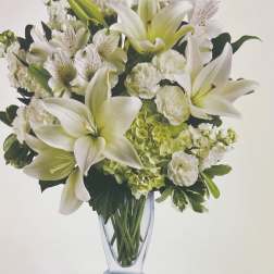 White lilies and green hydrangeas in a clear glass vase