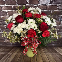 Red roses and white daisies in a vase with a strawberry-patterned bow
