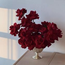 Red roses arranged in a decorative silver vase
