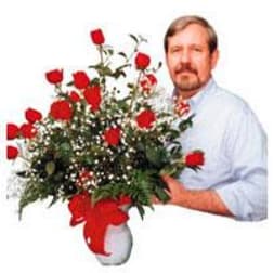 Large bouquet of red roses in a white vase with a red ribbon