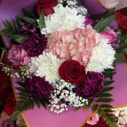 Bouquet of pink, white, and red flowers wrapped in pink paper