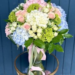 Pastel bouquet of hydrangeas and roses in a glass vase
