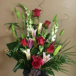 Tall bouquet of red roses and pink lilies with decorative greenery
