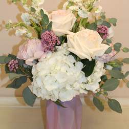 Bouquet of white and blush roses with hydrangea in a pink vase