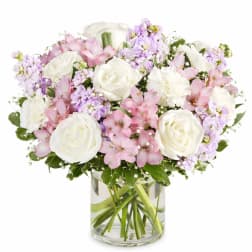 Pink and white bouquet of roses, alstroemeria, and carnations in a glass vase