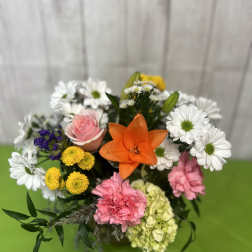 Mixed bouquet with a pink rose, orange lily, and white daisies