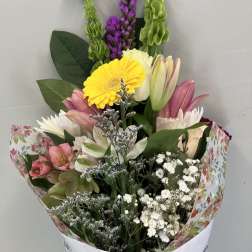 Mixed bouquet with pink lilies, yellow gerbera, and white filler flowers