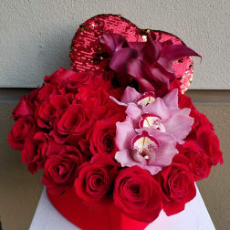 Red roses with pink orchids in a heart-shaped box