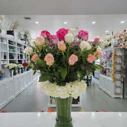 Tall bouquet of pink and white roses in a glass vase
