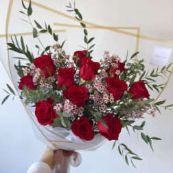 Bouquet of red roses with pink filler flowers and greenery