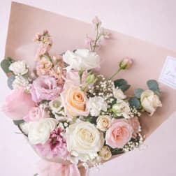 Hand-tied bouquet of pink and white roses with small white filler flowers
