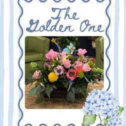 Mixed pink and purple flower arrangement in a low rectangular container