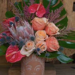 Bouquet of peach roses and pink anthuriums in a terracotta vase