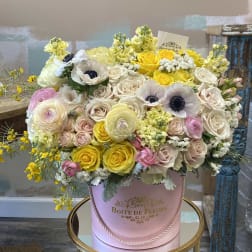 Large pastel flower arrangement in a pink hatbox