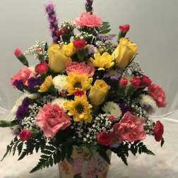 Colorful mixed flower arrangement in a floral tin container