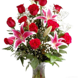 Red roses and pink lilies in a clear glass vase