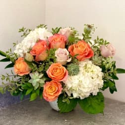 Peach roses and white hydrangeas in a low vase arrangement