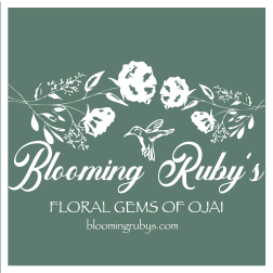 Blooming Ruby's floral shop logo on a green background with white flowers and a hummingbird