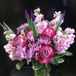 Pink and purple bouquet of roses and chrysanthemums in a glass vase