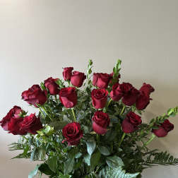 Bouquet of red roses with greenery in a clear vase