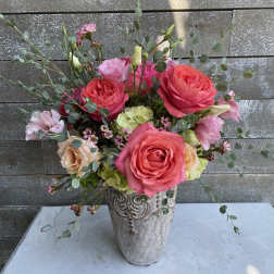 Pink and peach roses arranged in a decorative vase
