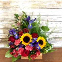 Mixed bouquet with sunflowers, red roses, purple irises, and pink carnations