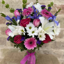 Bouquet of pink roses, white lilies, and daisies with purple accents