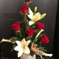 Red roses and white lilies arranged in a white vase