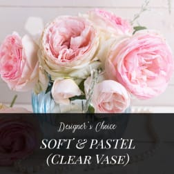 Soft pink and white roses in a clear glass vase