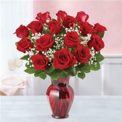 Red roses arranged in a red glass vase