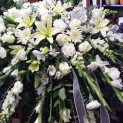Large white funeral spray with lilies, roses, and carnations