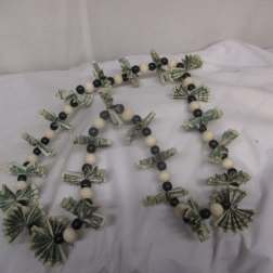 Beaded garland with folded dollar bills on a white cloth