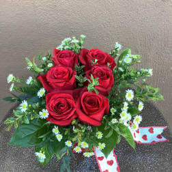 Red roses with small white daisies and a heart ribbon