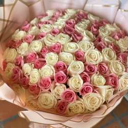 Bouquet of pink and cream roses wrapped in pale pink paper