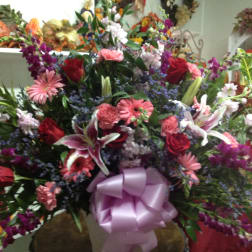 Large mixed bouquet with roses, lilies, and pink gerbera daisies in a vase